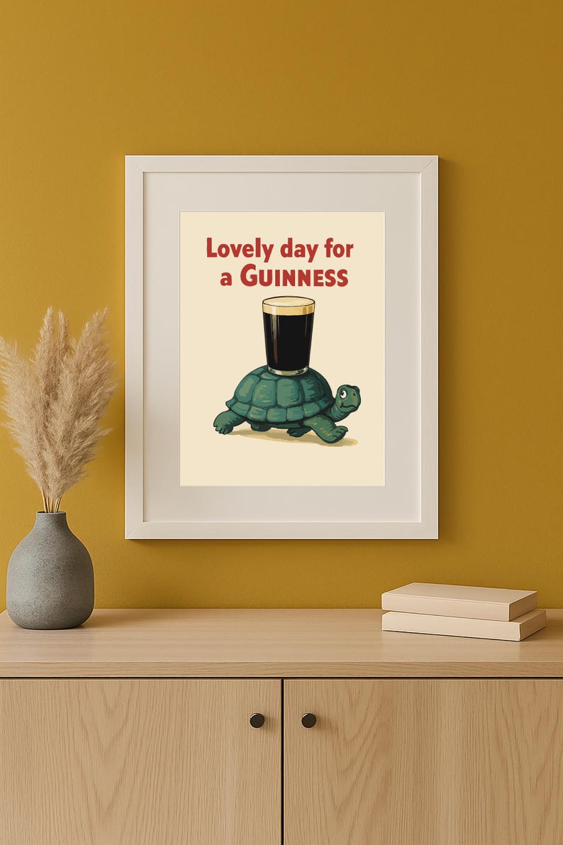 Puede incluir: Impresi&oacute;n enmarcada que presenta una tortuga de dibujos animados que lleva una pinta de Guinness. El texto "Lovely day for a Guinness" es rojo. La obra de arte se muestra en un marco blanco.