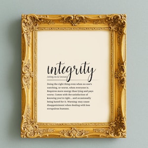 May include: A framed print with a gold ornate frame. The print features the word "integrity" in a stylish script font, along with its pronunciation and definition. The definition is written in a clear, easy-to-read font.