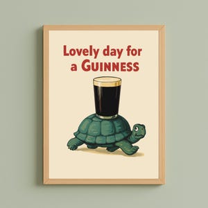 Puede incluir: Impresi&oacute;n enmarcada con una tortuga de dibujos animados que lleva una pinta de Guinness. El texto "Lovely day for a Guinness" est&aacute; encima de la tortuga. La obra de arte tiene un estilo vintage, con un fondo crema y un marco de madera.