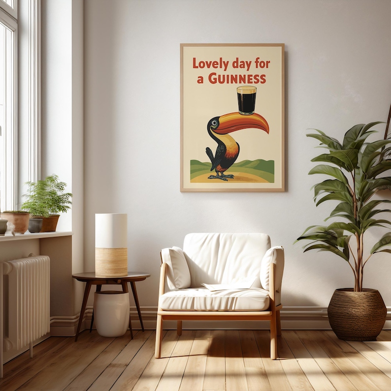 May include: A framed vintage-style poster featuring a toucan balancing a pint of Guinness. The poster has the text "Lovely day for a Guinness" in red. The toucan is black, orange, and yellow, set against a cream background.