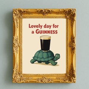 Puede incluir: Impresi&oacute;n enmarcada con un marco dorado ornamentado. La imagen presenta una tortuga de dibujos animados con una pinta de Guinness en la espalda. El texto "Lovely day for a Guinness" est&aacute; encima de la tortuga.