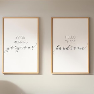 Puede incluir: Dos impresiones enmarcadas con texto. La impresión de la izquierda dice "GOOD MORNING gorgeous" en escritura negra sobre blanco. La impresión de la derecha dice "HELLO THERE handsome" en escritura negra sobre blanco. Ambas en marcos marrones claros.