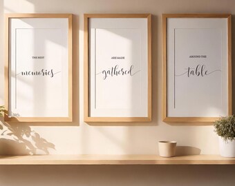 May include: Three framed prints with white backgrounds and black text. The text on the left print reads "The best memories are made". The text on the middle print reads "gathered". The text on the right print reads "around the table".
