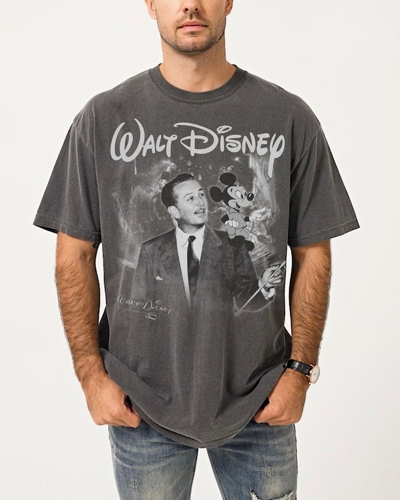 May include: Dark gray t-shirt featuring a vintage graphic of Walt Disney with Mickey Mouse. The text "Walt Disney" is arched above the image. The shirt has a faded, distressed look.