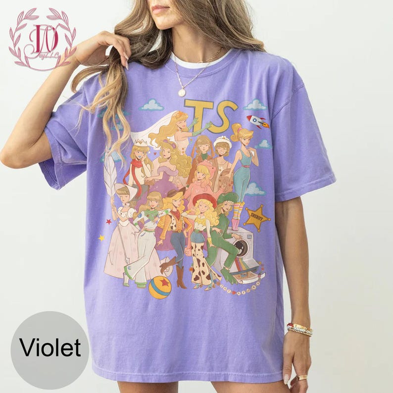 May include: A violet short-sleeve t-shirt featuring a graphic print of multiple animated characters in various outfits, including a cowgirl, a space ranger, and a sheriff badge. The text TS is printed in large yellow letters above the characters.