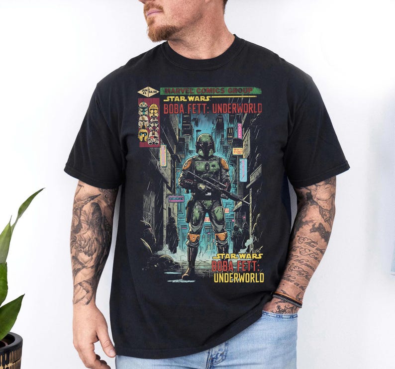 May include: Black t-shirt featuring a Star Wars comic book graphic. The graphic depicts Boba Fett in a futuristic city setting, with the text "STAR WARS BOBA FETT: UNDERWORLD" displayed prominently. The shirt is made of a soft material.