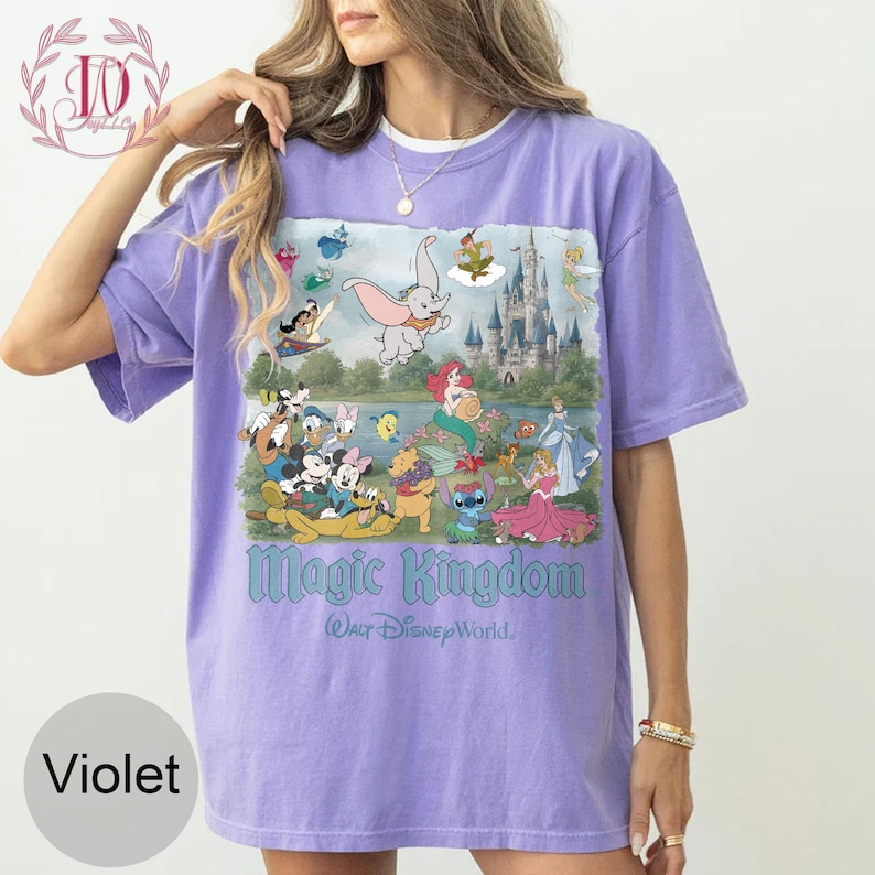 May include: A violet short-sleeve t-shirt featuring a graphic print of various Disney characters, a castle, and the text Magic Kingdom Walt Disney World. The design includes Dumbo, Ariel, Mickey Mouse, Minnie Mouse, Stitch, and other figures.