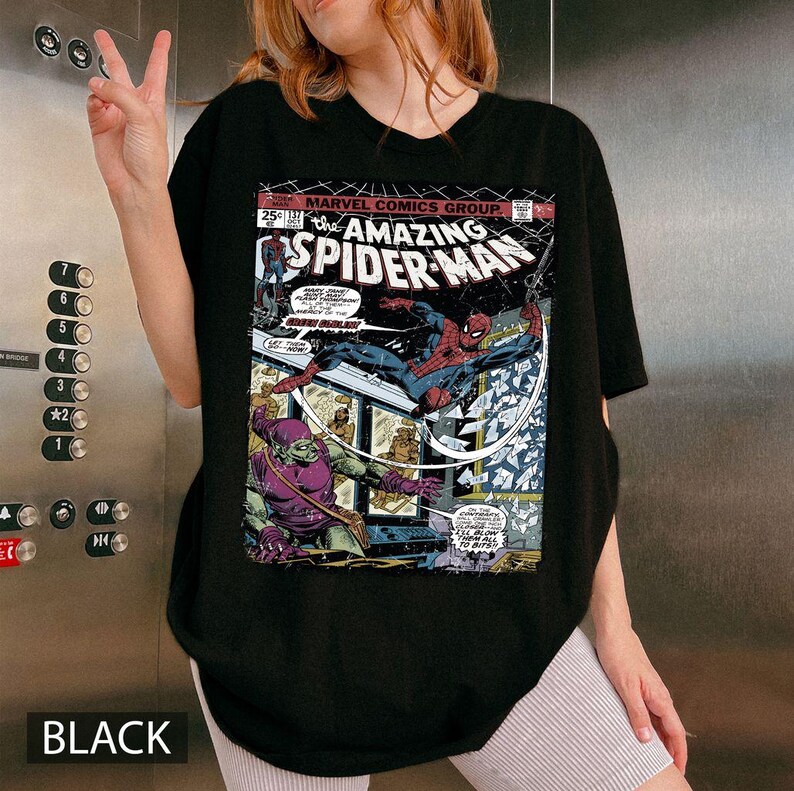 May include: Black t-shirt featuring a comic book cover of The Amazing Spider-Man. The graphic shows Spider-Man in action against the Green Goblin. The shirt also has the text "MARVEL COMICS GROUP" and "BLACK" at the bottom.