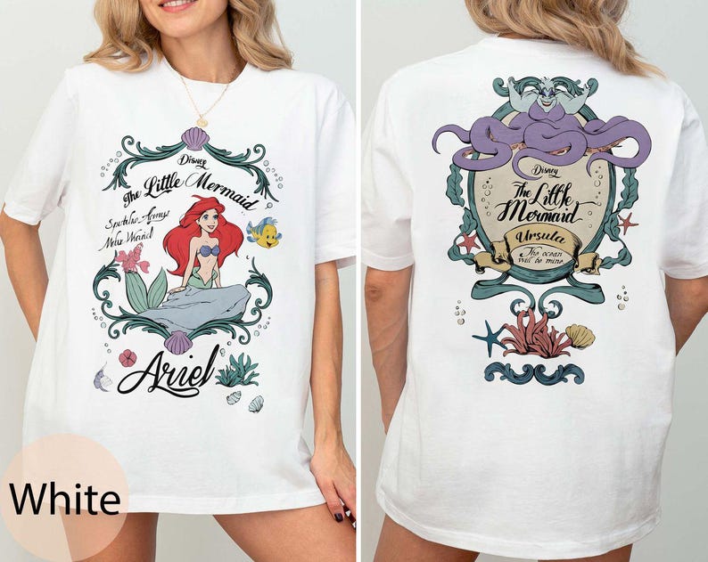 May include: White t-shirt featuring a front graphic of Ariel from Disney's The Little Mermaid, with the text "Ariel". The back graphic features Ursula, also from The Little Mermaid. The shirt has short sleeves.