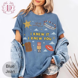 Puede incluir: Una camiseta azul de manga corta con el texto I KNEW IT I KNEW YOU, infinity and beyond, y YOU'VE GOT A FRIEND IN ME. Los gr&aacute;ficos incluyen una estrella de sheriff amarilla, una pulsera de cuentas, botas vaqueras marrones, bloques y un sombrero rojo.