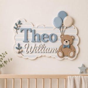 May include: A decorative wall sign featuring the name Theo William in blue and white lettering on a light blue striped cloud-shaped background. The sign includes a brown teddy bear with a blue bow tie and three balloons in blue and cream.