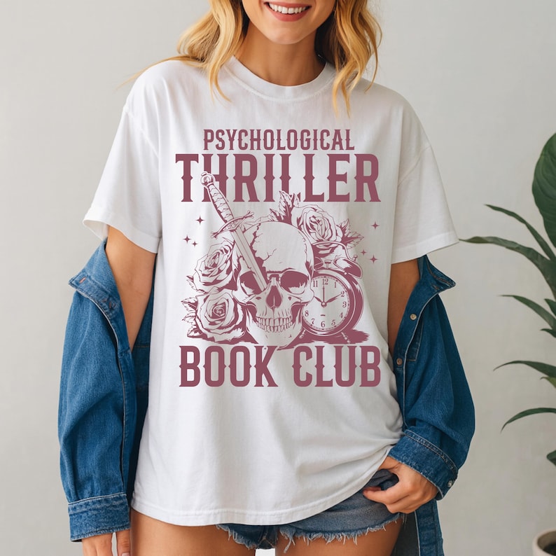 May include: White t-shirt with a burgundy graphic. The graphic features a skull pierced by a sword, surrounded by roses and a clock, with the words "PSYCHOLOGICAL THRILLER BOOK CLUB".