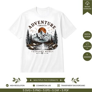 May include: A white t-shirt featuring a graphic illustration of a mountain range, a forest, and a lake under a large orange sun. The text ADVENTURE AWAITS is arched above the mountains, and EXPLORE MORE is printed below the lake with a compass icon.