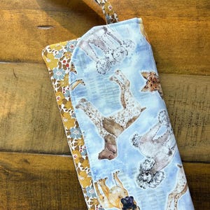 Cartera de tela de algodón con compartimento con cremallera y 6 ranuras para tarjetas. 19 cm de largo x 10 cm de ancho. Acolchada. Lavable y con cierre magnético.