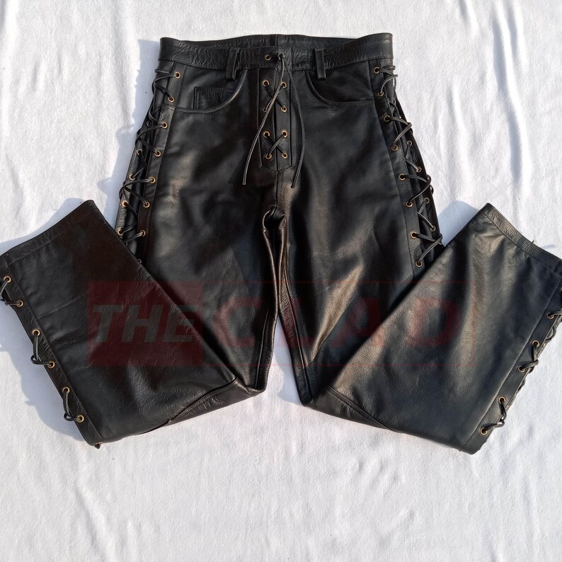 May include: Black leather pants with lace-up detailing on the sides. The pants have a classic five-pocket design and a relaxed fit.