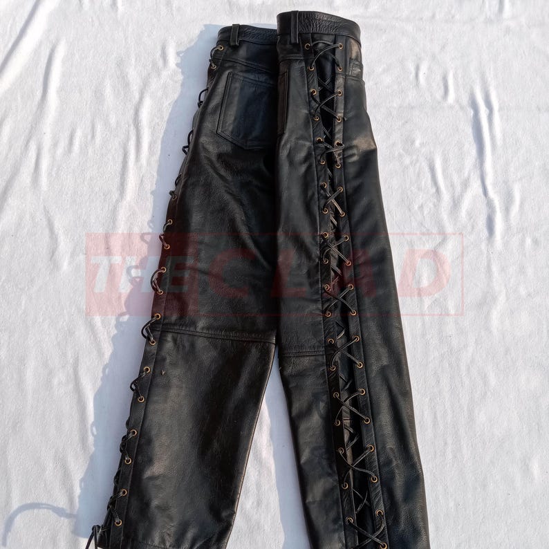 May include: Black leather pants with lace-up detailing on the sides. The laces are brown and the pants have a relaxed fit.