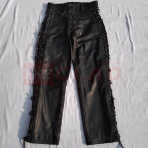 May include: Black leather pants with lace-up detailing on the sides. The pants have a straight leg and a classic five-pocket design.
