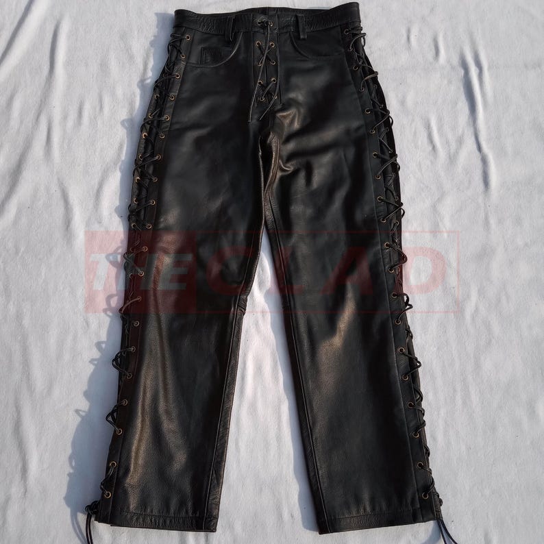 May include: Black leather pants with lace-up detailing on the sides. The pants have a straight leg and a classic five-pocket design.