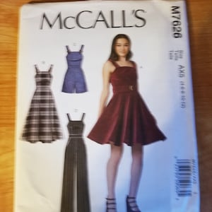 May include: A sewing pattern for a dress and jumpsuit. The pattern includes three different styles: a plaid dress, a denim jumpsuit, and a burgundy dress. The pattern is from McCall's and the pattern number is M7626.