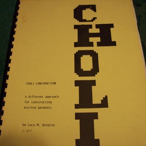 May include: A yellow book with the title "CHOLI CONSTRUCTION" and the word "CHOLI" in large black letters. The book is about a different approach to constructing knitted garments. The author is Lucy M. Desgrey.