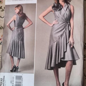 May include: A gray sleeveless dress pattern by Pamella Roland. The dress features a ruffled skirt, a belt, and a decorative flower detail at the shoulder. The pattern includes sizes 6-8-10-12.