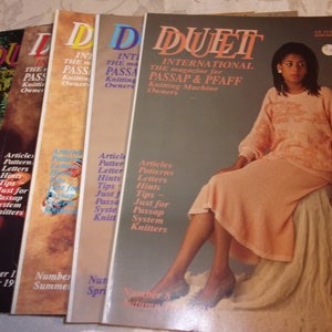 May include: A stack of five magazines titled "Duet International The magazine for Passap & Pfaff Knitting Machine Owners". The cover of the top magazine features a woman wearing a peach-colored knitted sweater and skirt.