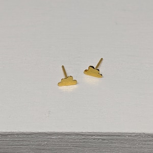 Könnte beinhalten: Ein Paar goldene Ohrstecker in Wolkenform.