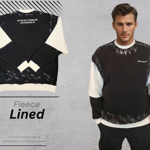 May include: Black and white fleece-lined sweatshirt with a white and black splatter design. The sweatshirt has the text "No one but ourselves can degrade us" on the front and "Don't give up" on the back.