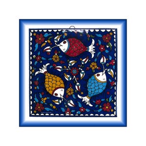 Puede incluir: Azulejo cerámico cuadrado con fondo azul que presenta tres peces coloridos y motivos florales. Los peces son rojos, amarillos y azules, con detalles blancos. El azulejo está enmarcado en un borde azul.