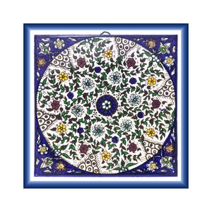 May include: A square ceramic tile featuring a central circular design filled with intricate green vines, yellow flowers, and dark red blossoms against a white background. The corners and edges are decorated with blue, white, and yellow patterns.