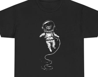 May include: Black t-shirt featuring a white illustration of a cat in an astronaut suit floating in space. The cat is wearing a helmet and space suit with a tether. The design is detailed and whimsical.