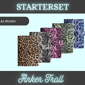 Könnte beinhalten: Eine Auswahl an A6-Ordnern mit Leopardenmuster in verschiedenen Farben, darunter Braun, Grau, Rosa, Grün und Blau. Der Text "STARTERSET" ist oben und "Anker Troll" unten zu sehen.