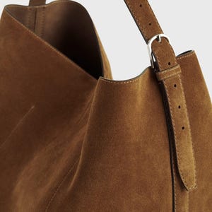 Luxury handmade brown suede tote purse with spacious design genuine leather construction and a stylish yet functional shoulder strap
Premium quality oversized suede leather tote in brown for women perfect for work travel or everyday errands with comfortable strap length
Versatile brown suede leather tote bag for women with adjustable strap and roomy design suitable for all seasons and fashion styles
Handcrafted brown suede leather shoulder bag for women offering timeless elegance durability and