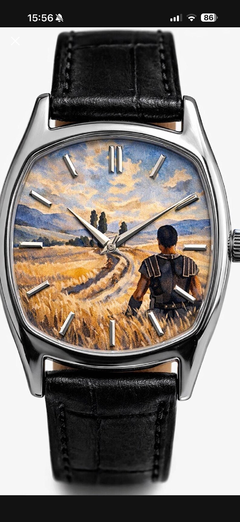 May include: A wristwatch with a silver-toned case and a black leather strap. The watch face features a detailed painting of a person standing in a golden wheat field under a blue sky, with silver-toned hour markers and three central hands.