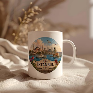 Peut inclure: Un mug en céramique blanche orné d'une illustration circulaire représentant les toits d'Istanbul, la tour de Léandre, un bateau et un verre de thé. Le mot ISTANBUL est inscrit sur une bannière décorative au bas du motif circulaire.
