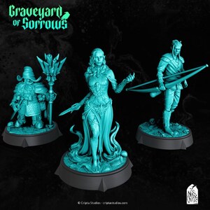 May include: Three teal fantasy miniatures: a dwarf with a staff, a female elf with a sword, and an elf with a bow. The figures are on black bases. The text "Graveyard of Sorrows" is at the top. The miniatures are made of resin.