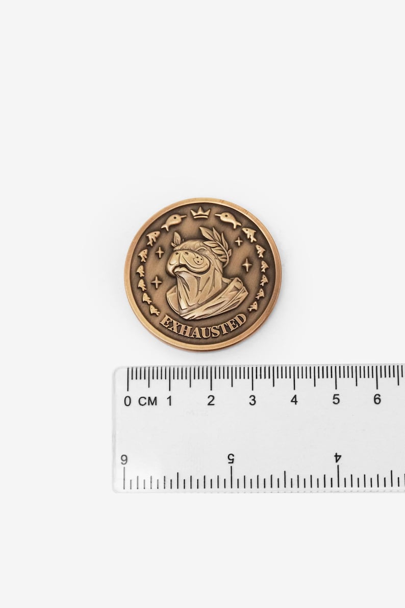Riftbound Gold token coin next to a ruler showing its 38mm size — zinc alloy, Urf the Manatee antique finish