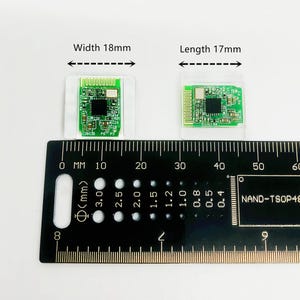 May include: Two small green circuit boards, one 18mm wide and the other 17mm long, are displayed on a white surface. A black ruler with millimeter markings and the text "NAND-TSOP48" is in the foreground.