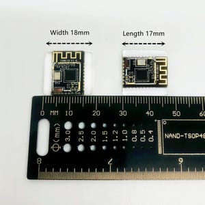 May include: Two small black and gold electronic components, each mounted on a clear plastic base, are displayed next to a ruler. The components measure 18mm wide and 17mm long. The ruler is marked in millimeters.