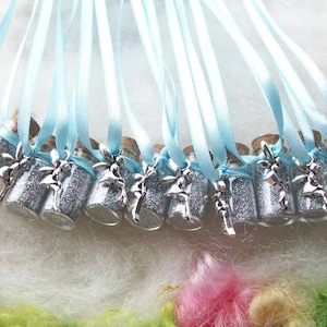 May include: A set of 12 silver glitter filled glass bottles with cork stoppers and silver fairy charms attached to light blue satin ribbons.