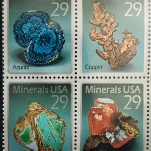 May include: A sheet of four "Minerals USA" postage stamps, each with a 29-cent value. The stamps feature images of Azurite, Copper, Variscite, and Wulfenite minerals, with their names printed below. The background is a teal color.