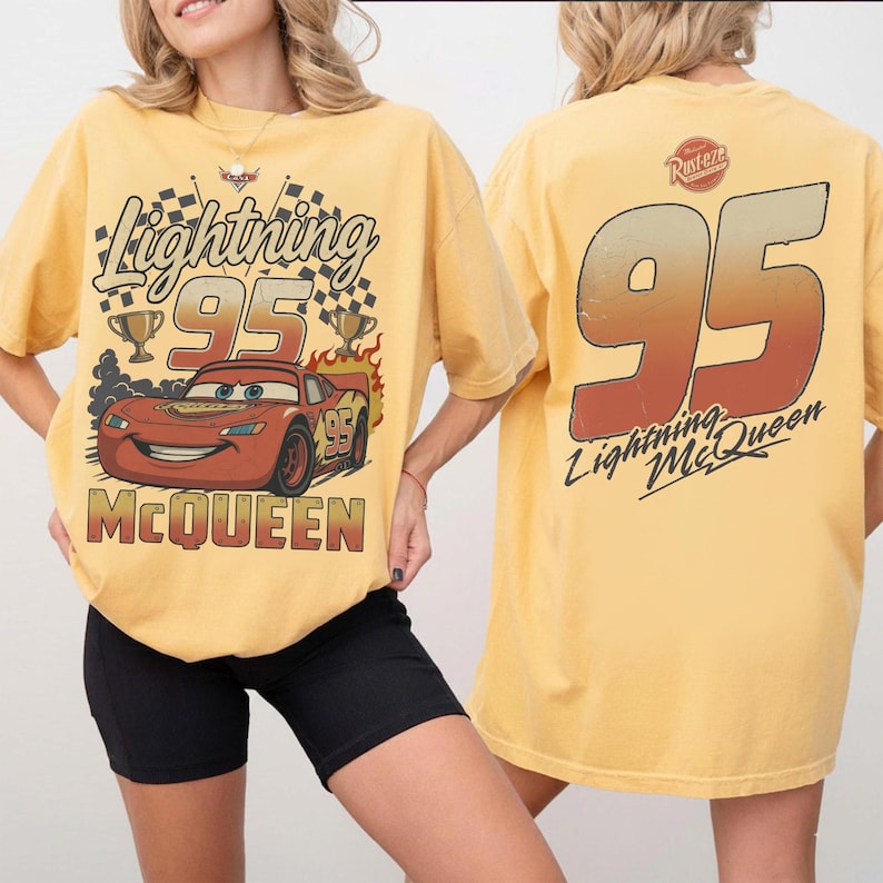 May include: A yellow t-shirt featuring a graphic of the red race car Lightning McQueen with the number 95, checkered flags, and trophies on the front. The back displays a large number 95 in a red-to-yellow gradient with the text Lightning McQueen.