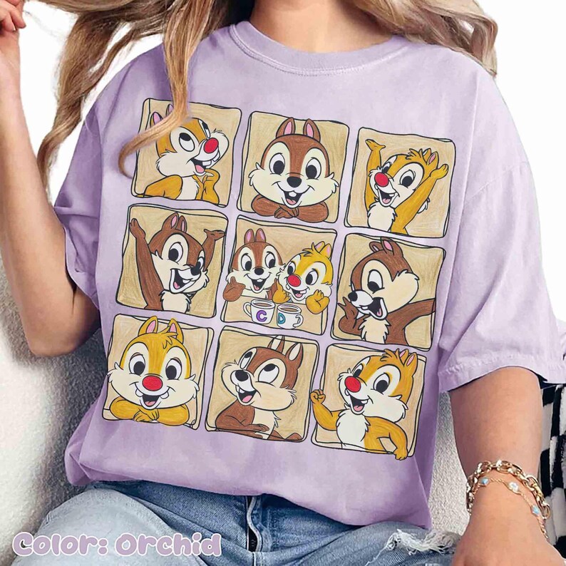 May include: Orchid-colored t-shirt featuring a grid of cartoon chipmunks in various poses. The chipmunks are in brown and yellow with red noses. The shirt has a relaxed fit and is made of soft material. The text "Color: Orchid" is at the bottom.