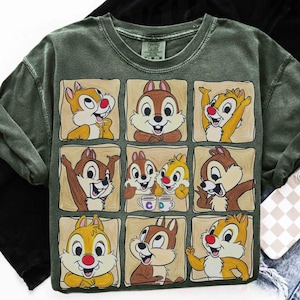 May include: Green crew neck sweatshirt featuring a grid of nine cartoon chipmunks in various poses. Each chipmunk has a red nose and is set against a tan background. The sweatshirt has a vintage wash effect.