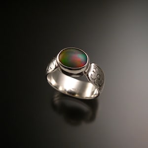 Könnte beinhalten: Ein silberner Ring mit floralem Design und einem großen ovalen, irisierenden Abalone-Muschel-Edelstein.