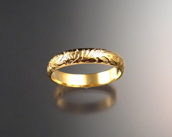 May include: A simple gold band ring with a floral design engraved around the entire band.
