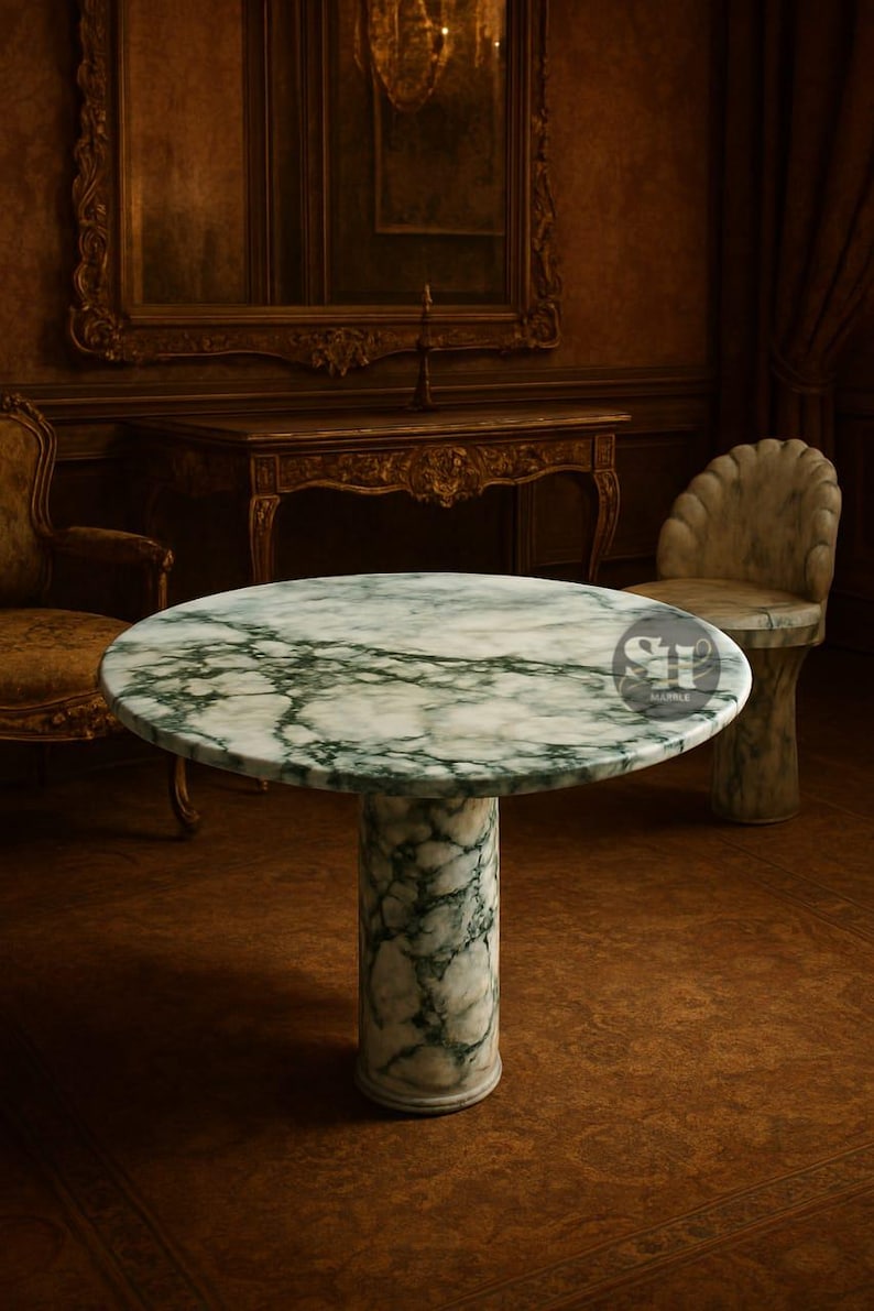 Puede incluir: Una mesa redonda de m&aacute;rmol con un patr&oacute;n veteado verde y blanco. La mesa tiene una base de pedestal cil&iacute;ndrica. La mesa est&aacute; en una habitaci&oacute;n con muebles antiguos y una silla de m&aacute;rmol.