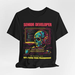 May include: Black t-shirt with a colorful graphic of a skull wearing headphones and a computer monitor. The text "SENIOR DEVELOPER" is above the graphic, and "10% Writing Code 90% Fixing State Management" is below.