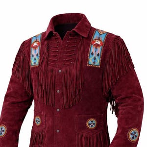May include: A burgundy suede jacket with fringe detailing and beaded accents. The jacket features a collared neckline, button-up front, and decorative patches with an eagle motif. The sleeves and pockets are adorned with circular beaded designs.