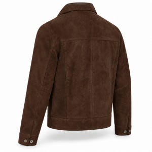 Peut inclure: Une veste en daim marron fonc&eacute; vue de dos, dot&eacute;e d'un col rabattu, de manches longues avec poignets boutonn&eacute;s, d'un empi&egrave;cement horizontal dans le dos et de coutures verticales s'&eacute;tendant de l'empi&egrave;cement jusqu'&agrave; l'ourlet droit.